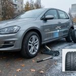 Процес заміни шин на автомобілі при температурі +7°C восени.